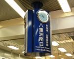 八重洲南口の新幹線イメージの青地にホワイトラインの
ボードと吊り下げ三面時計。06.10.25.